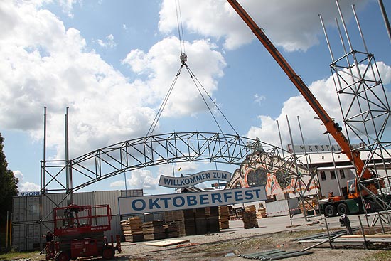 Das Willkommensschild wird hochgezogen beim Wiesn-Aufbau am 14.08.2019 (©Foto: Marikka-Laila Maisel)